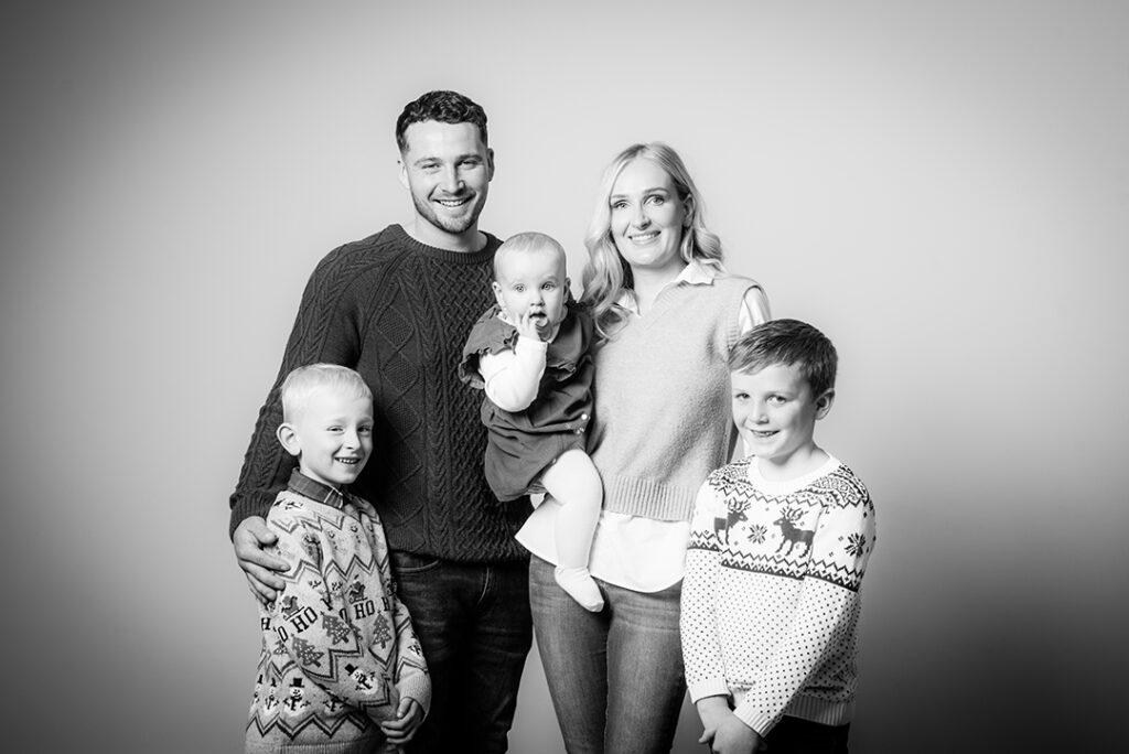 "A family smiling together during a relaxed portrait session at Stables Photography Studios in Abergavenny, South Wales"